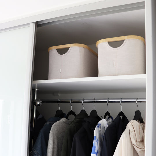 Beige tekstilbokser på øverste hylle i skyvedørsgarderobe for ryddig klesoppbevaring