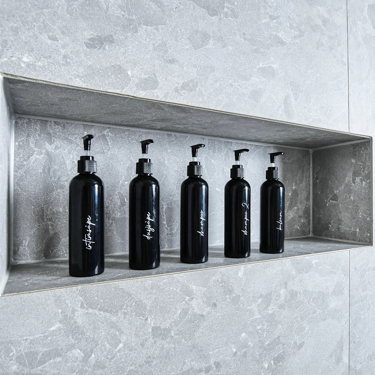 Sorte pumpeflasker med hvite etiketter på bad